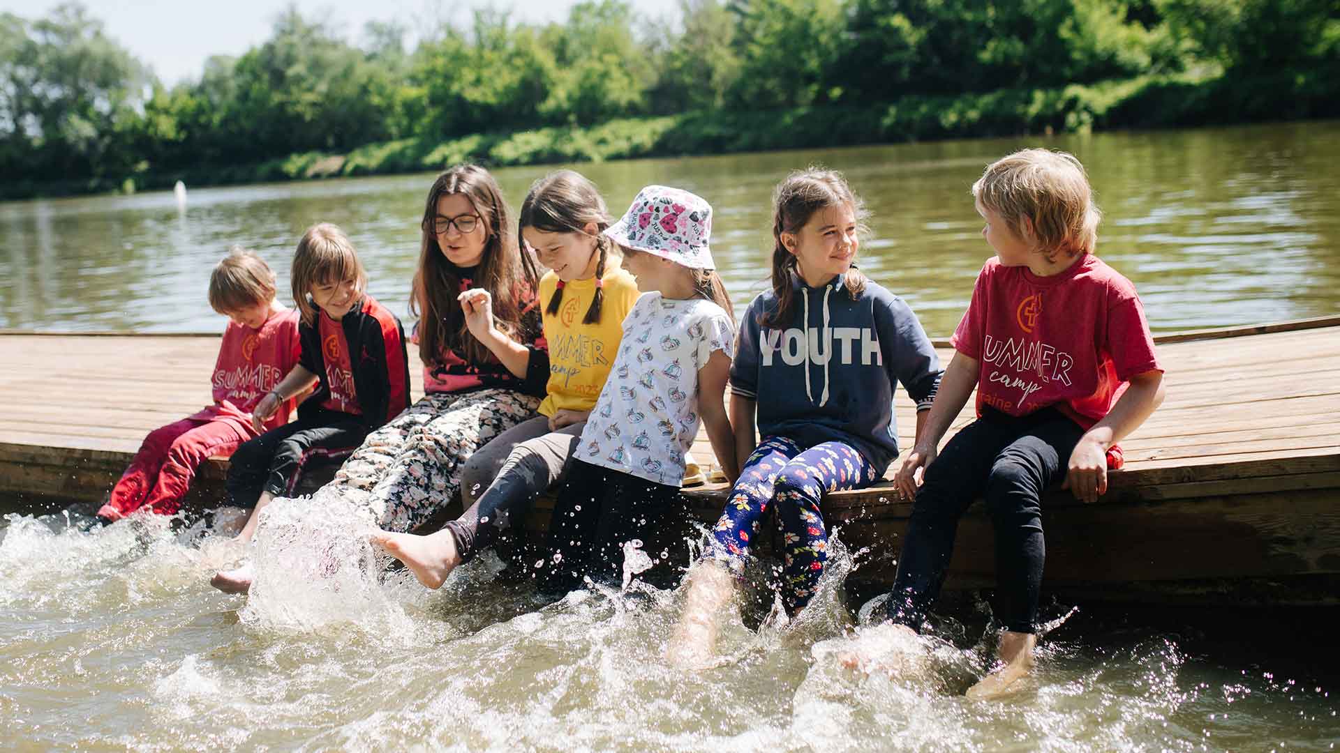 Children have fun splashing in water at a summer camp.